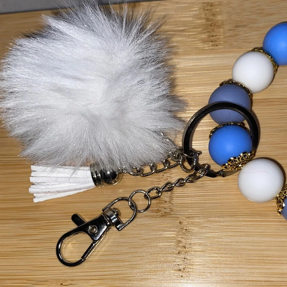 Blue and white bracelet keychain with white pom-pom